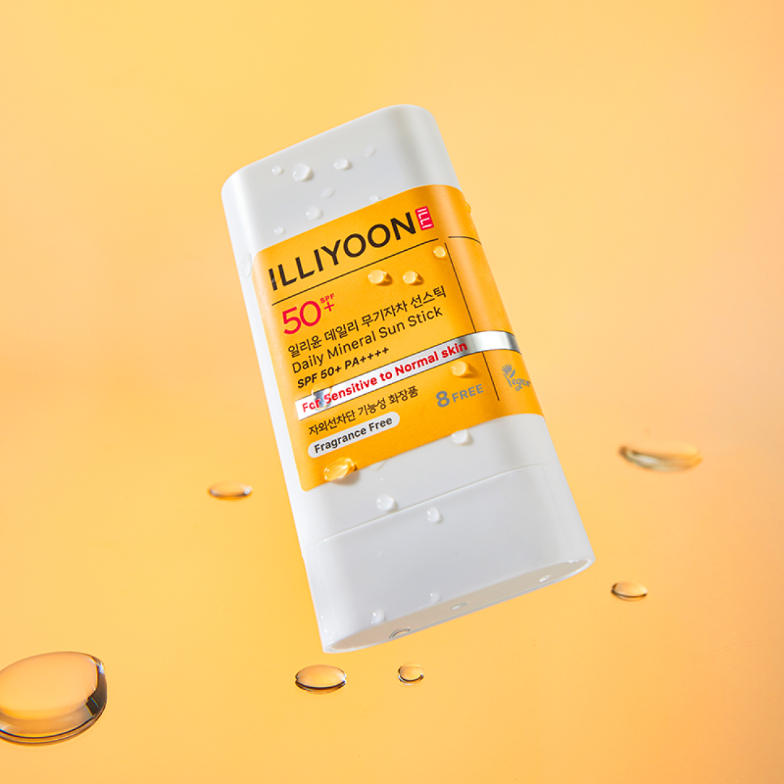 ILLIOYOON Daily Weaponless Sun Stick 20g on a glossy orange background with water droplets, highlighting sensitive skin use.