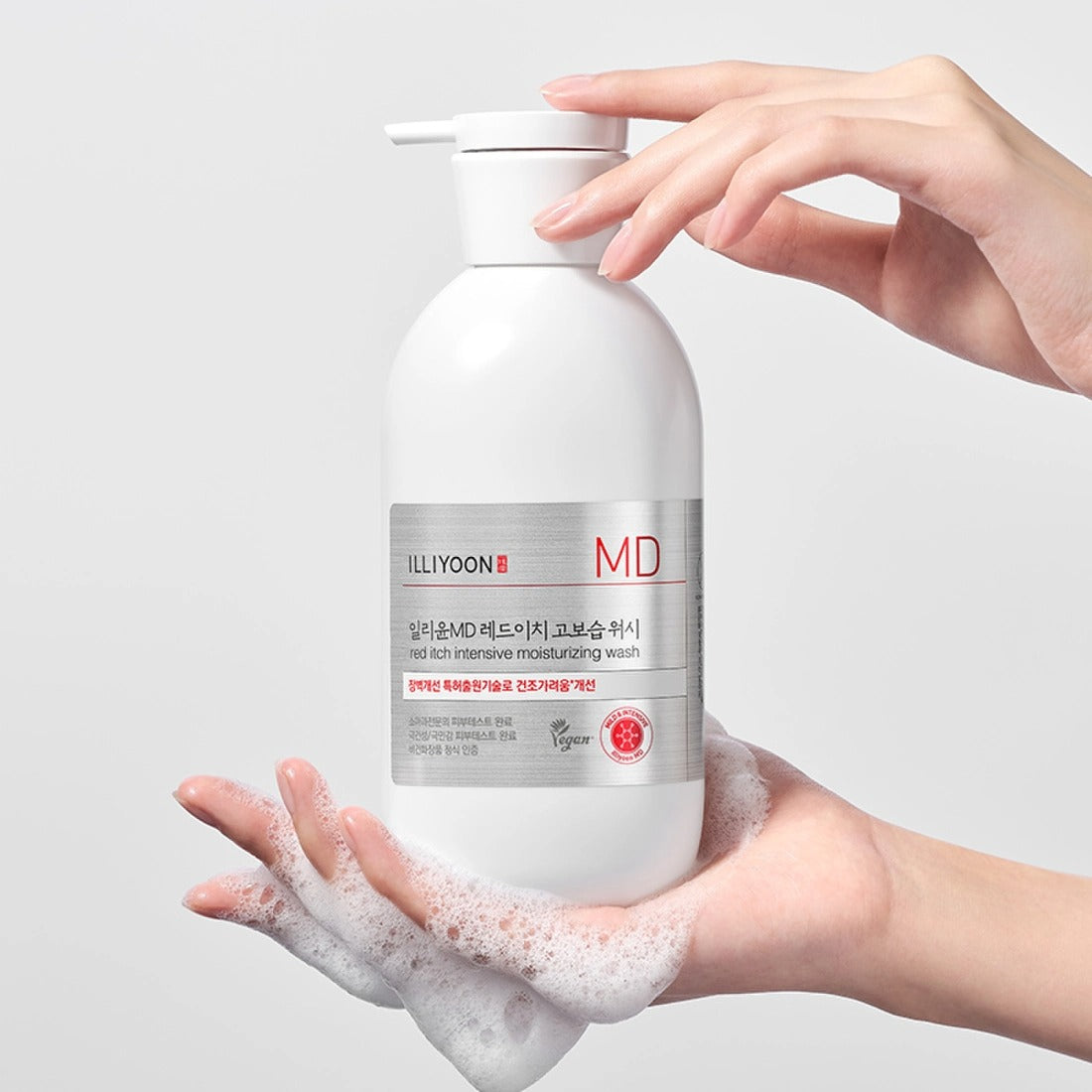 Hands holding ILLIYOON Redich High Moisture Wash 470g bottle with foam, showcasing product packaging.
