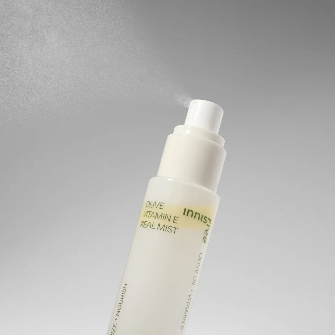 INNISFREE Olive Vitamin E Real Oil Mist 75ml in a white spray bottle with misting effect against a gray background.
