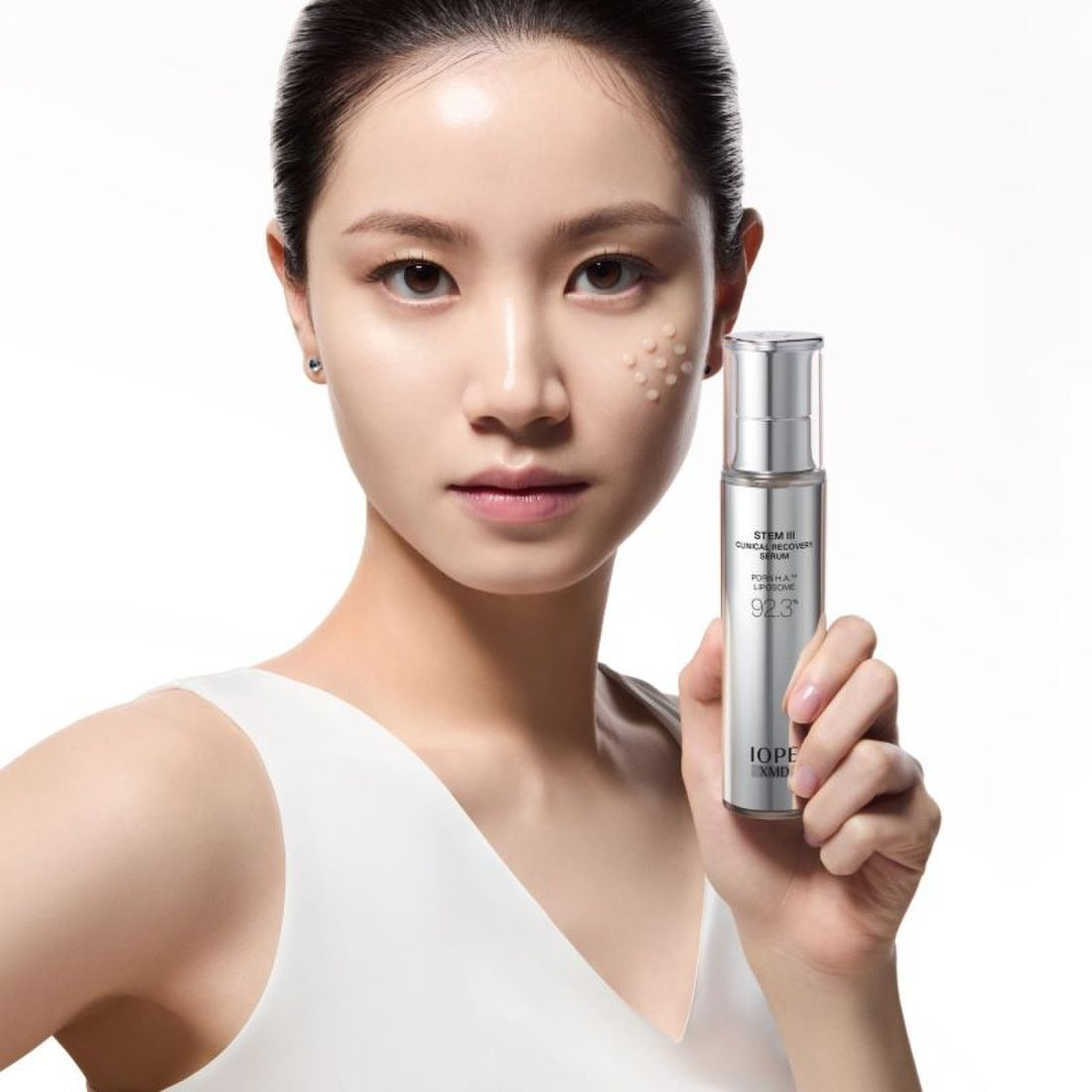 IOPE XMD Stem3 Clinic Recoery Serum 50ml held by model showcasing skincare benefits.
