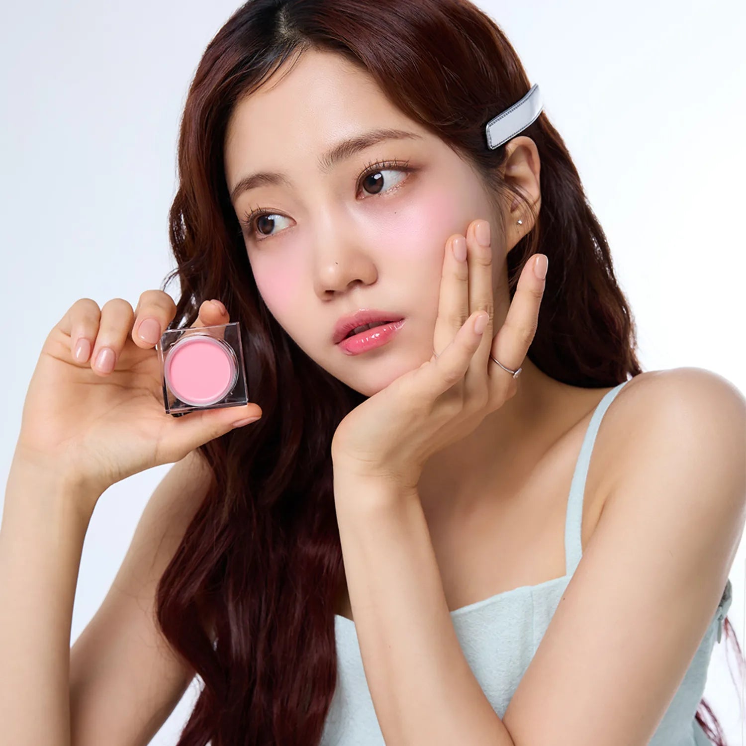 Woman holding IVI MAD PEACH Mood Mix Cream Blusher showcasing product application.