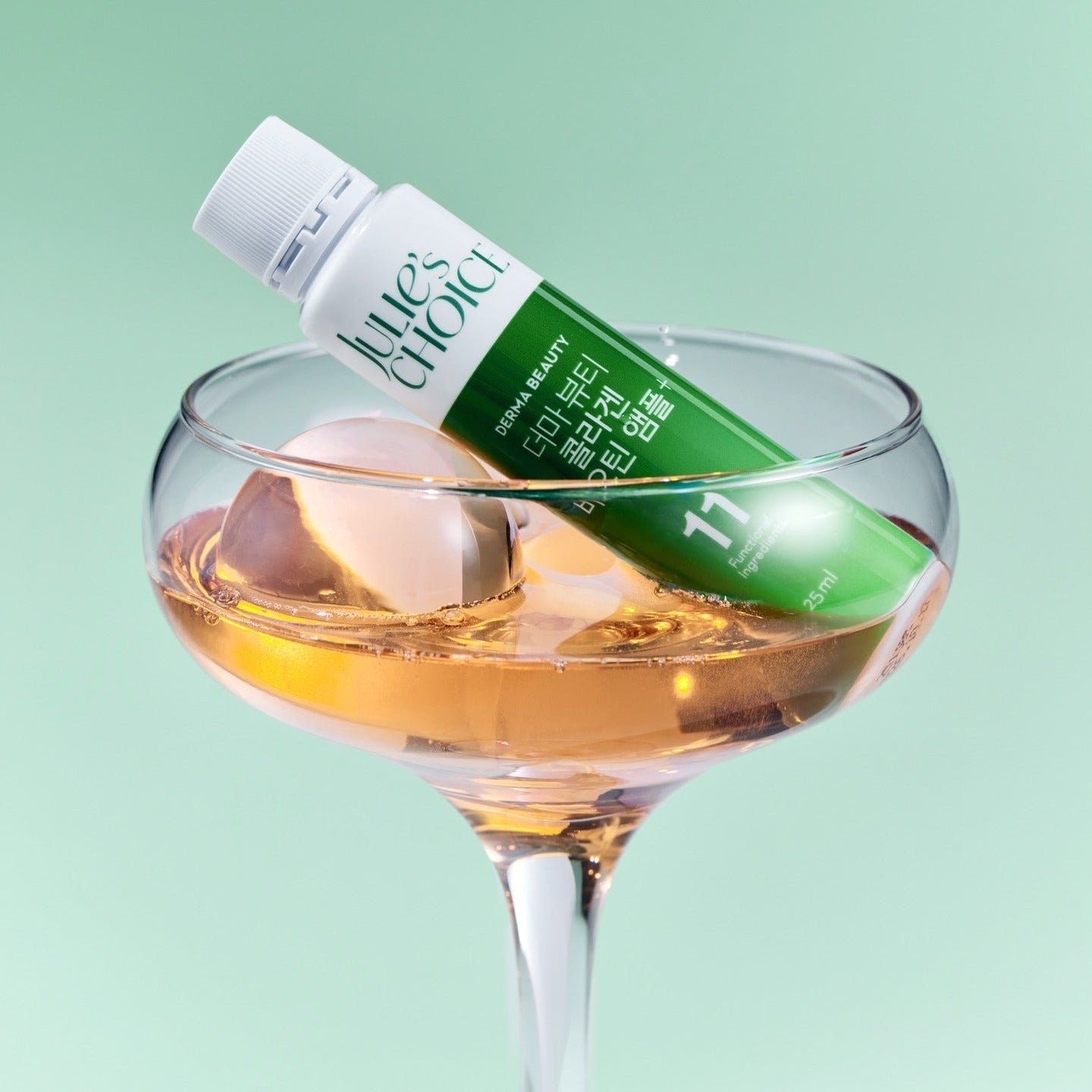 JULIE'S CHOICE Derma Beauty Collagen Biotin Ampoule 25ml in a glass with ice, showcasing the beauty product in a stylish setting.