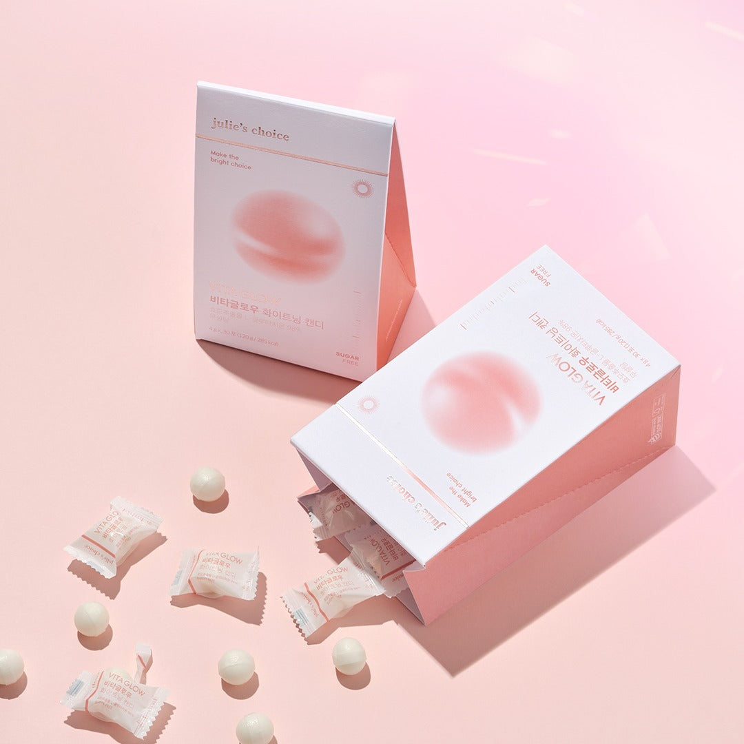 JULIE'S CHOICE Vita Glow Whitening Candy packaging with scattered candies on a pink background.