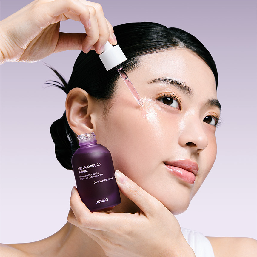 Woman applying JUMISO Niacinamide 20 Serum 40ml with a dropper for radiant skin care.