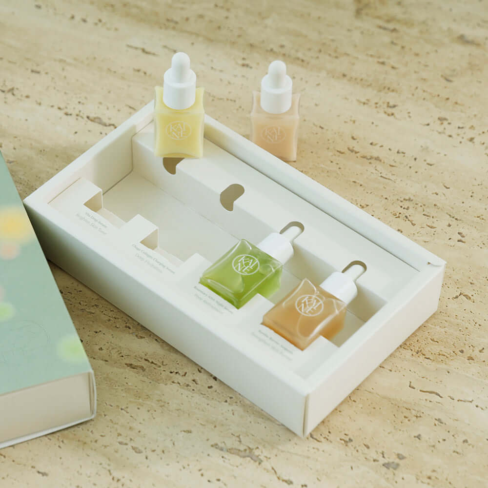 KAINE Serum Discovery Kit with three different serum bottles in an elegant packaging, set on a textured background.