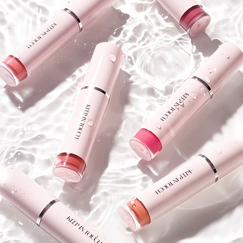 Assorted KEEP IN TOUCH Glow Water Lip Tint tubes on water surface showcasing various shades