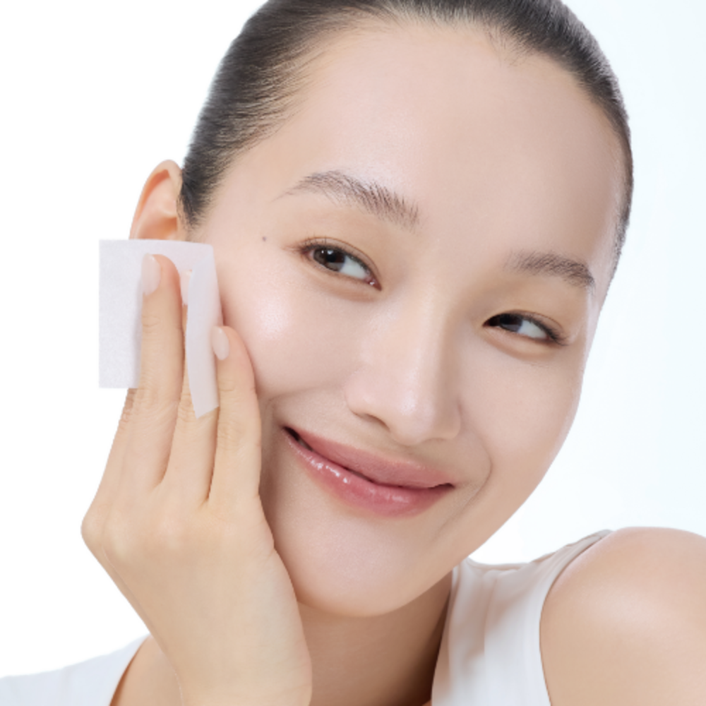Woman using KLAIRS Freshly Juiced Vitamin Hwajalmeok Pad 80 sheets on her face for a glowing complexion.