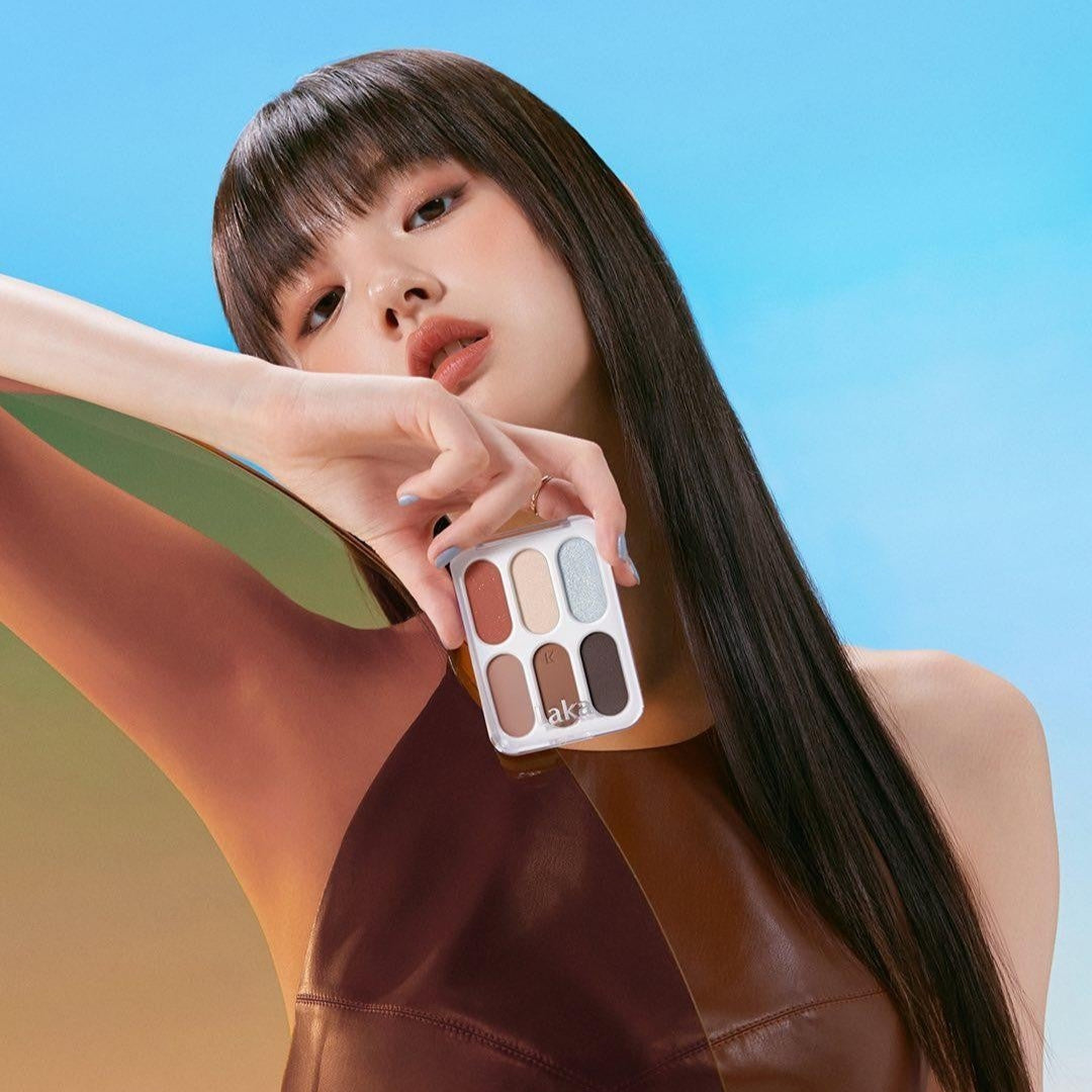 Model holding LAKA Forever 6 Eye Palette against a colorful background.