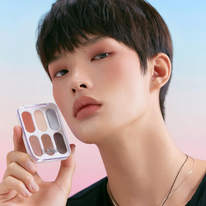 Model holding LAKA Forever 6 Eye Palette against colorful backdrop