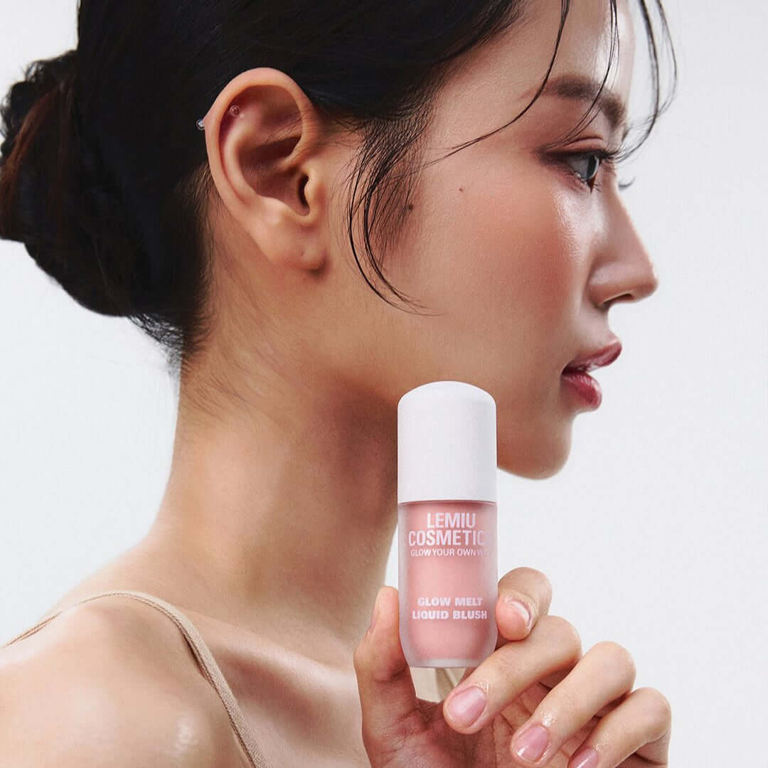Side profile of a woman holding LEMIU Glow Melt Liquid Blush to her cheek