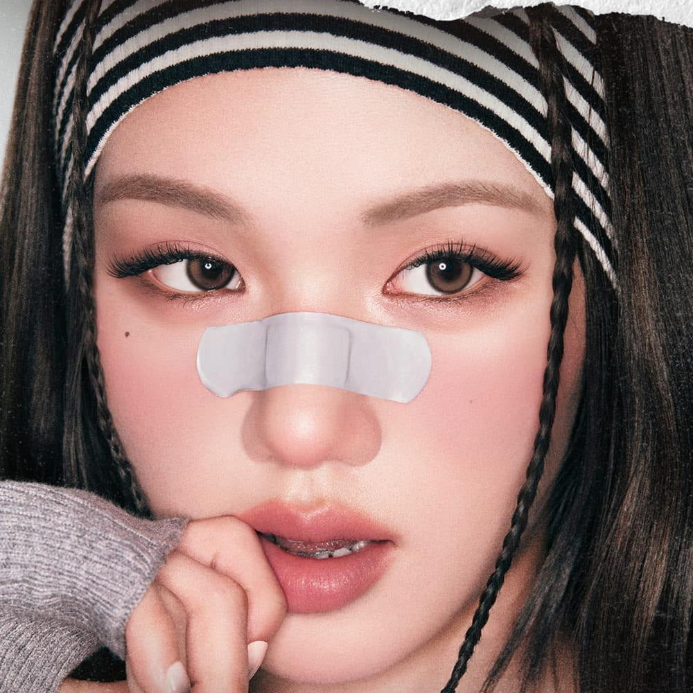 Fashionable model with a nose strip and striped headband for skincare advertisement.