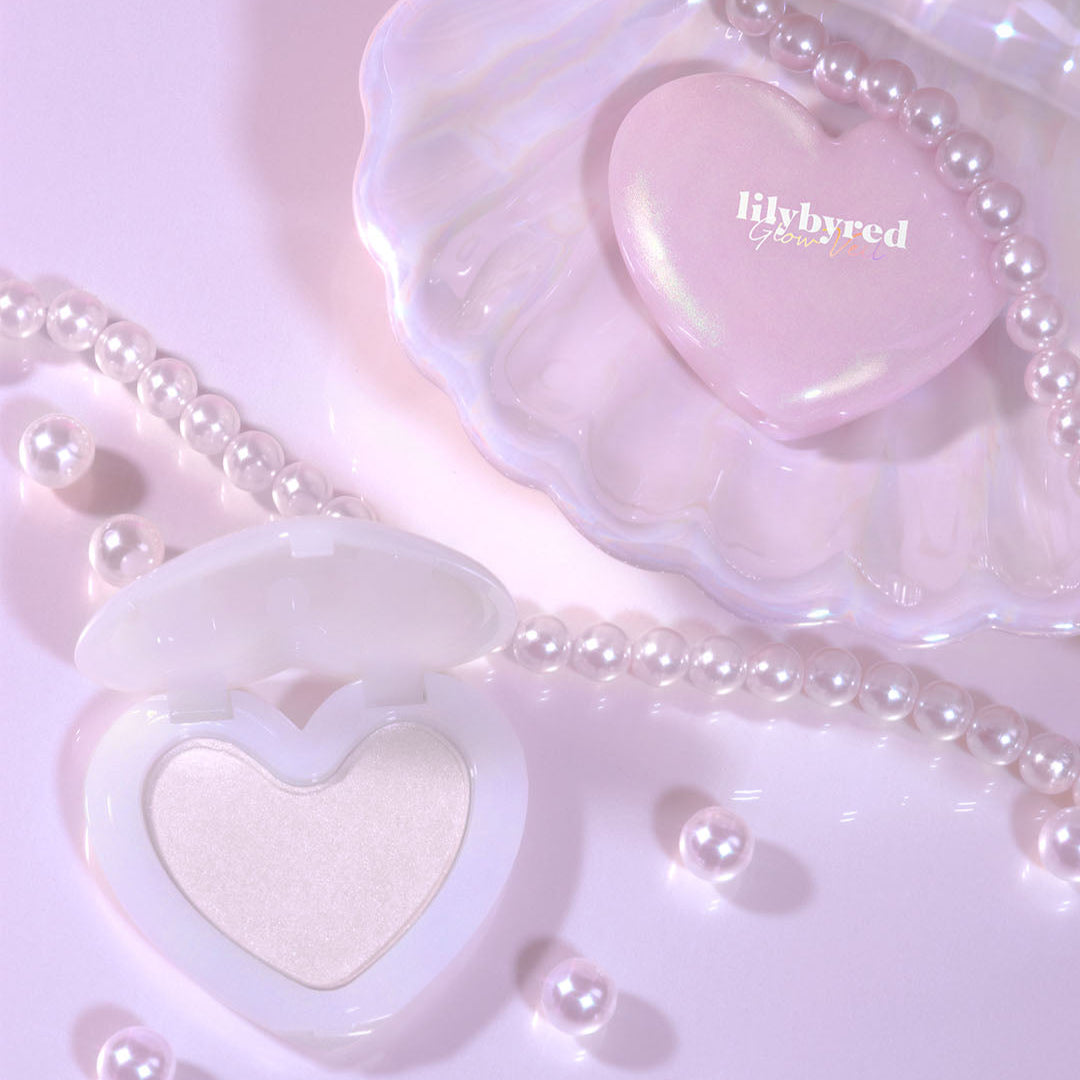 LILYBYRED Love Beam Glow Veil compact heart-shaped makeup with pearl accents, enhancing a soft and radiant glow.