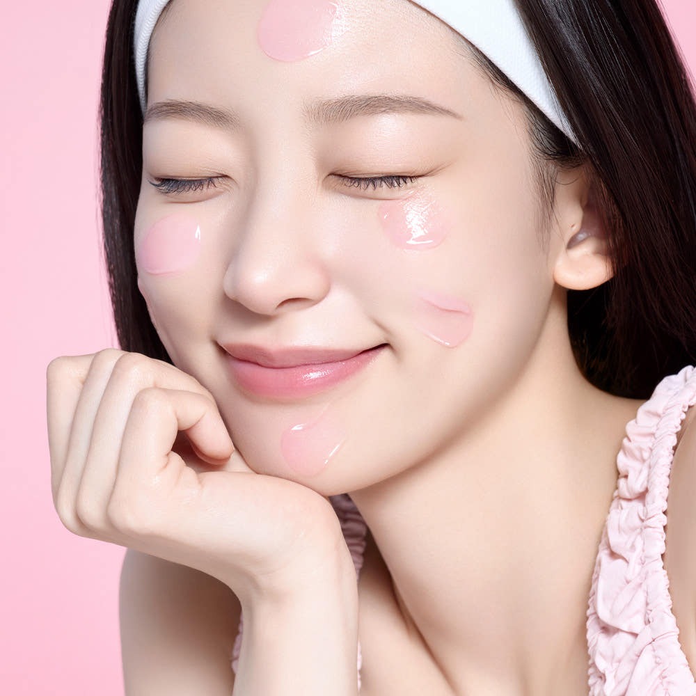 Woman applying MAMONDE Flora Glow Rose Sleeping Mask 80ml on her face, showcasing the skincare product's hydrating properties.