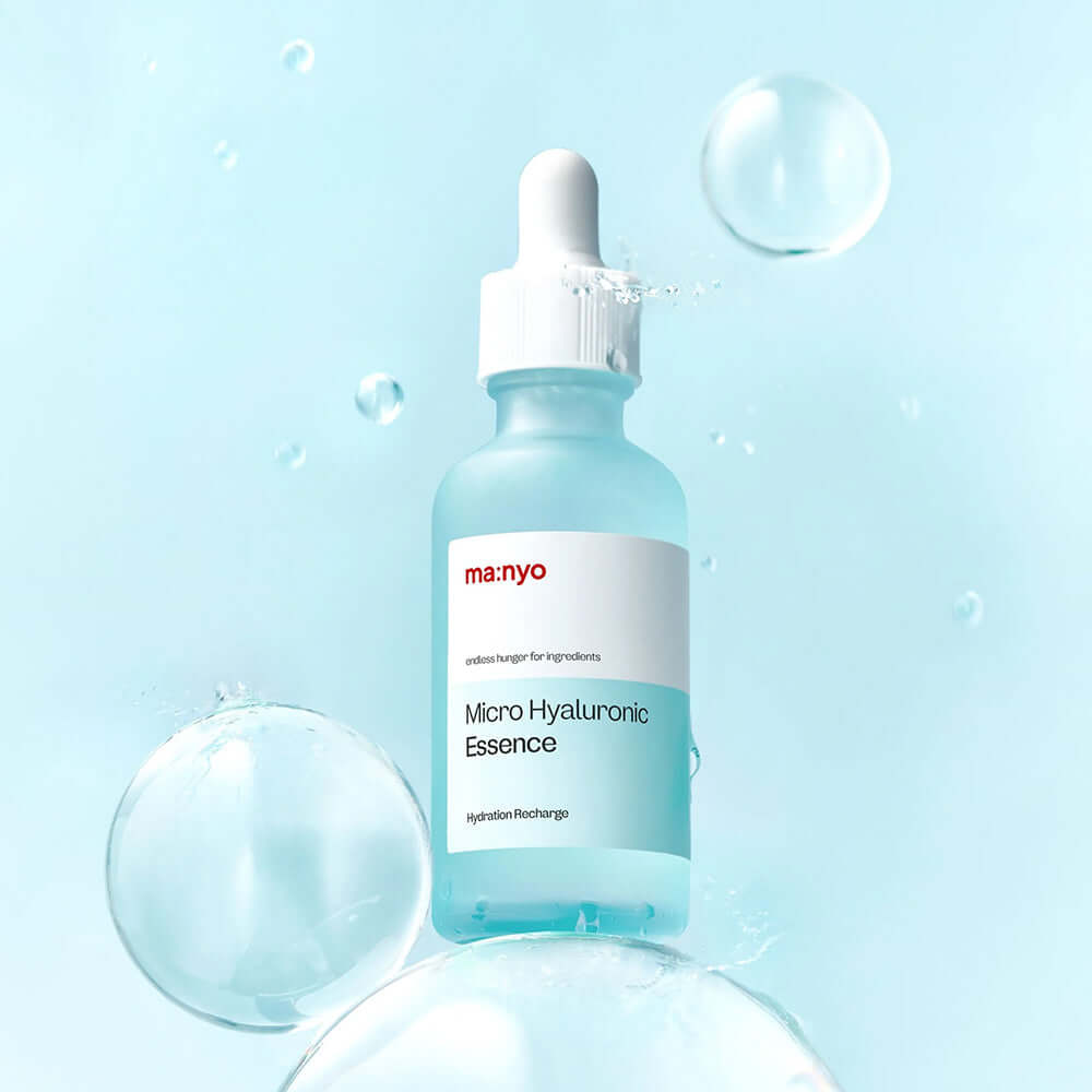 Bottle of MANYO Micro Hyaluronic Essence 50ml surrounded by bubbles on a blue background.