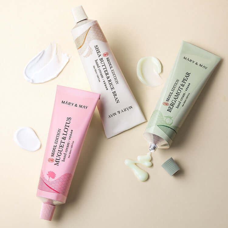 MARY & MAY Hand Cream Trio Set featuring MUGWORT & LOTUS, SHEA BUTTER & MACADAMIA, and BERGAMOT & PEAR creams with swatches.