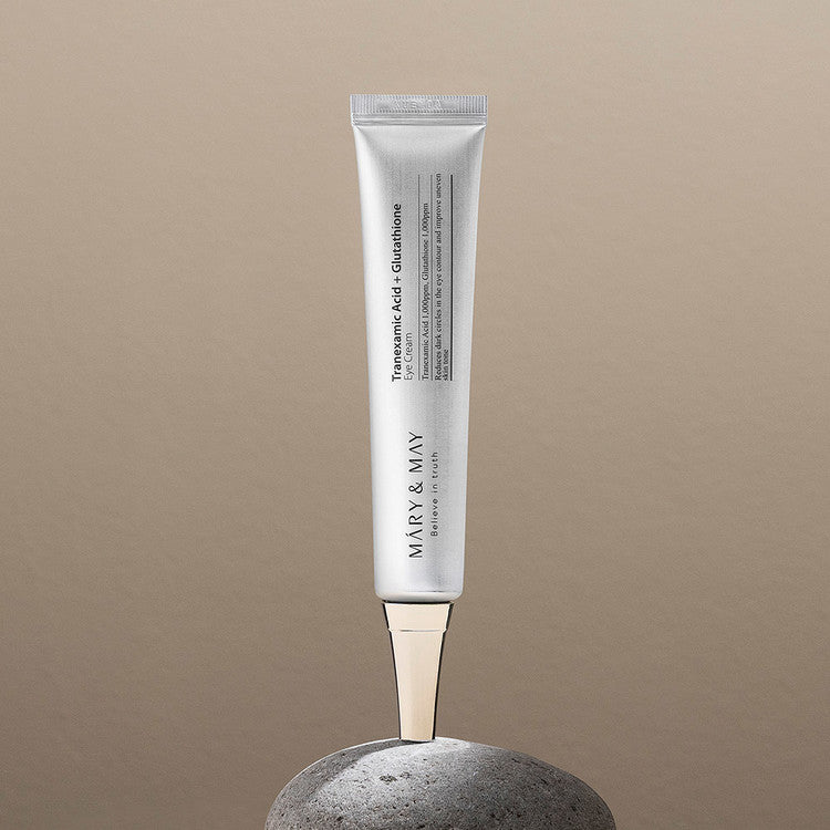 MARY&MAY Tranexamic Acid Glutathione Eye Cream 30ml tube displayed on stone background