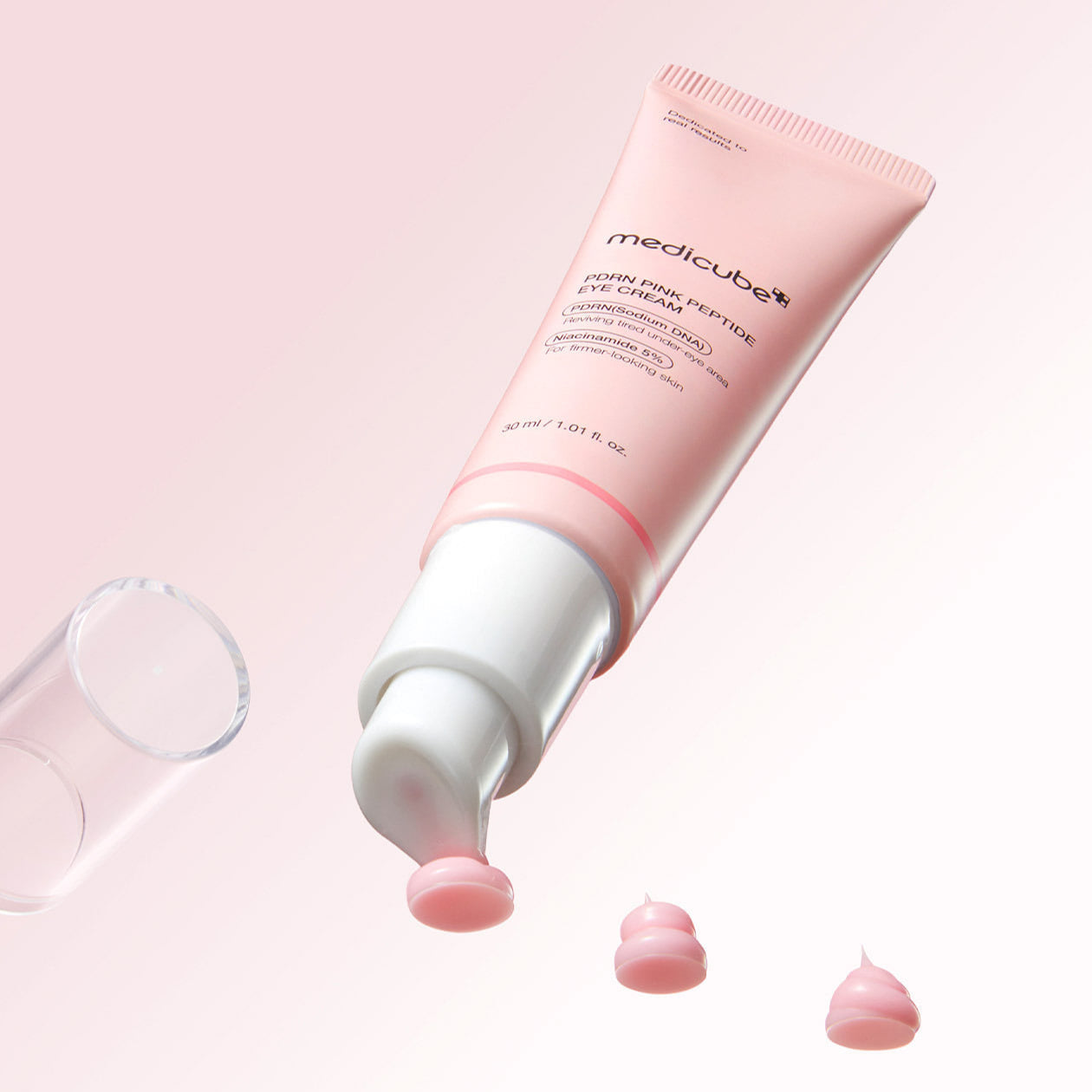 MEDICUBE PDRN Pink Peptide Eye Cream 30ml packaging with cream on a pink background.