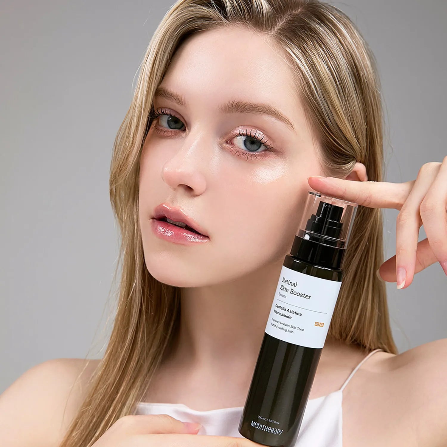Woman holding a bottle of MEDITHERAPY Retinal Skin Booster Serum 150ml for skincare