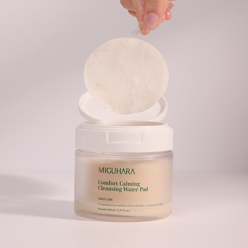 MIGUHARA Comfort Calming Cleansing Water Pads 70 Sheets pack with open lid showcasing one pad being lifted out.