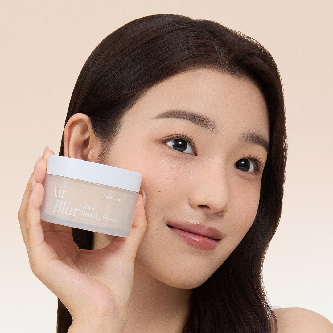 Woman holding MILK TOUCH Air Blur Rice Setting Powder with a smile