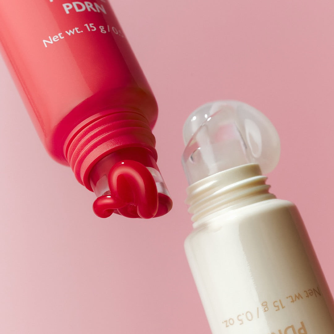 Close-up of MILK TOUCH Glow Up Collagen Lip Balm 15g with open tube showing balm texture and elegant design on pink background