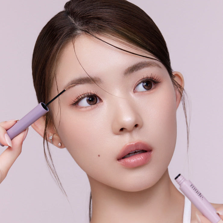 Woman applying MUDE Inspire Skinny Brow Cara for perfect eyebrows.
