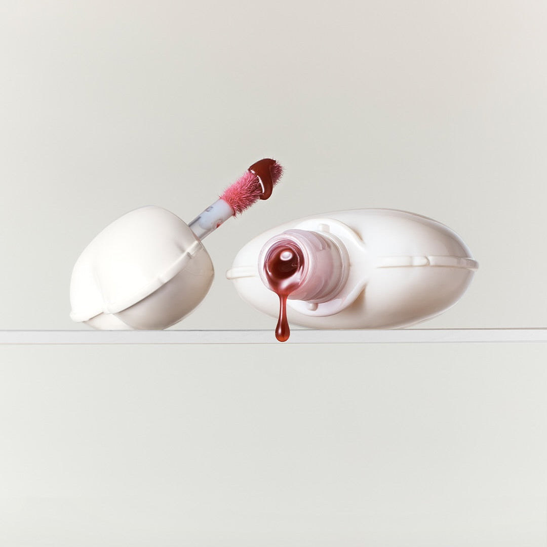 NAMING Glow Heart Lip Tint product with open applicator and drop of color.