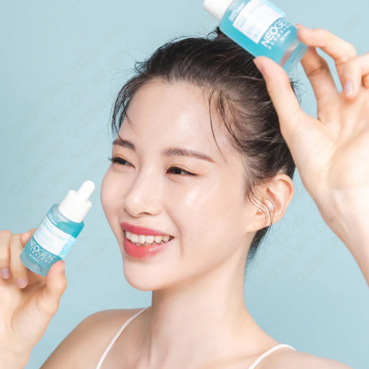 Smiling woman holding NEOGEN Real Hya Panthenol Serum 30ml against a blue background.