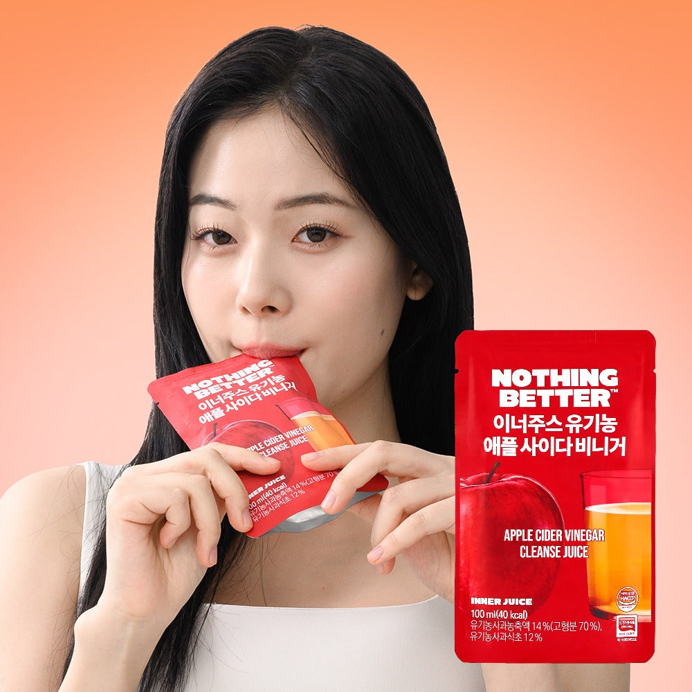 Woman sipping NOTHING BETTER Inner Juice Apple Cider Vinegar Cleanse Juice (X24) in red packaging, health and wellness product.