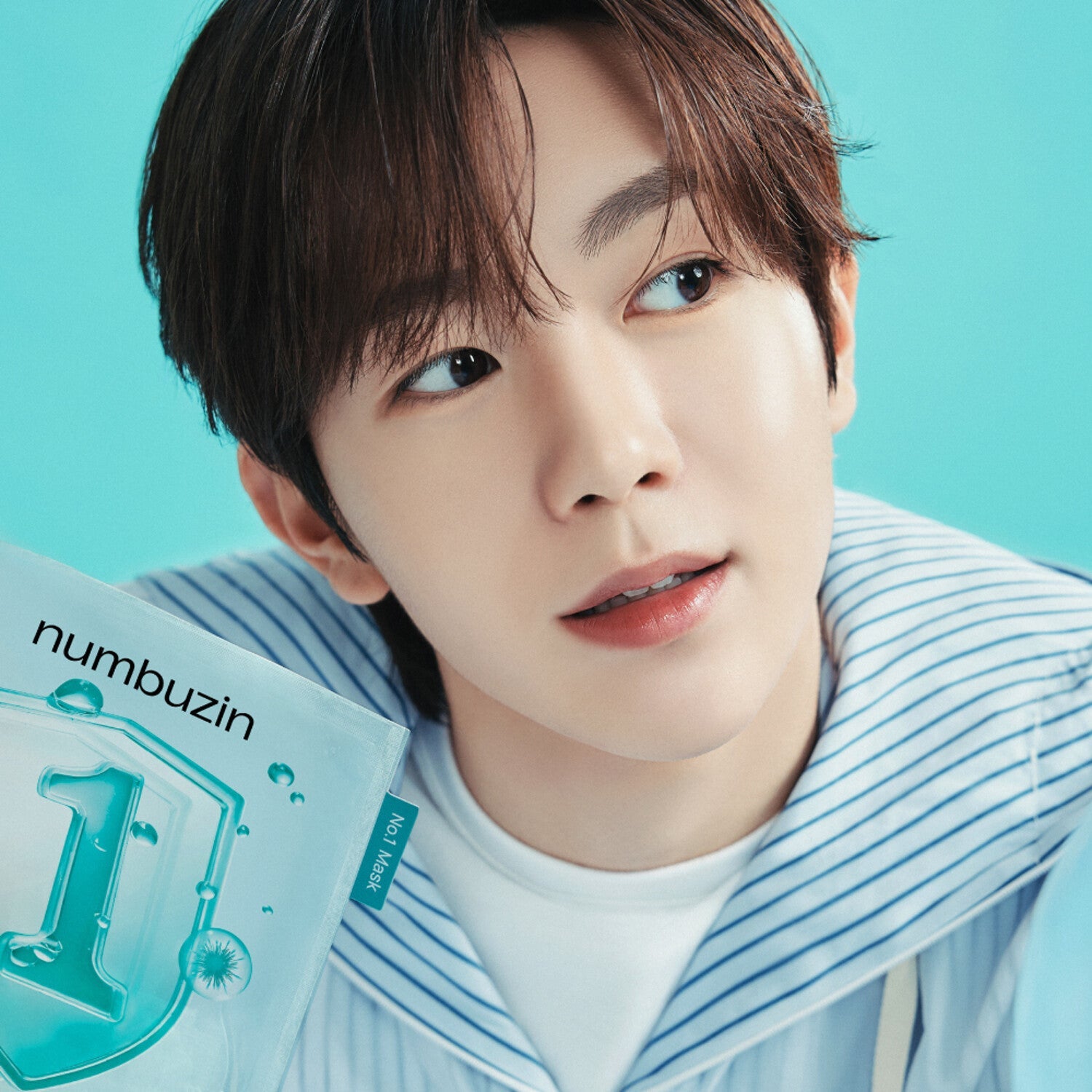 Person holding a box of NUMBUZIN No.1 Hyaluronic Panthenic Acid Clear Soothing Gauze Pack 10 sheets with a bright blue background.