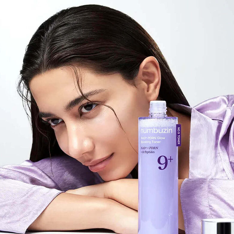 NUMBUZIN No.9 NMN PDRN Glow Boosting Toner 150ml with woman resting her head on her arms in a lavender blouse.