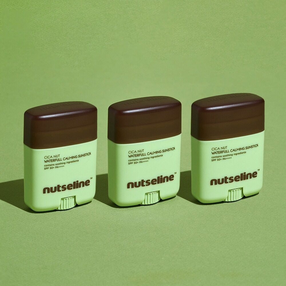 Three NUTSELINE Cica Nut Waterful Calming Sun Stick 20g products on green background
