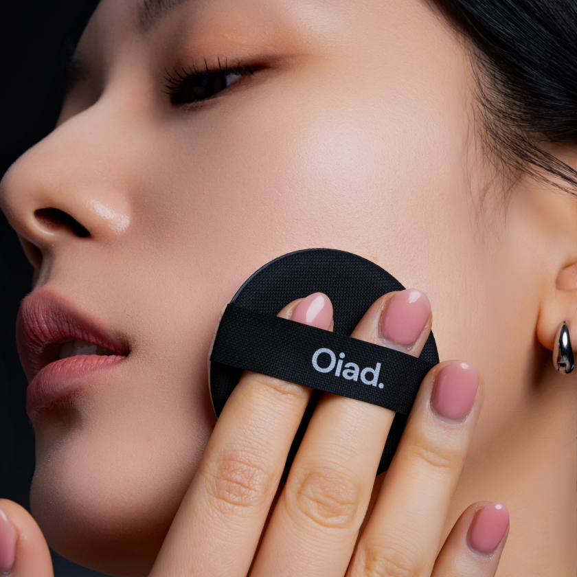 Woman applying OIAD Pore Perfecting Mirror Moon Cushion for flawless skin finish.