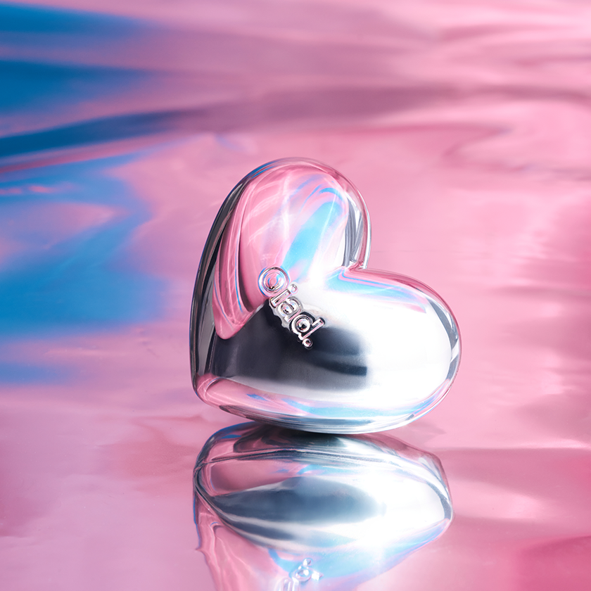 OIAD Silverpulse Moussecream Lip&Cheek in a heart-shaped metallic container with pink and blue background.
