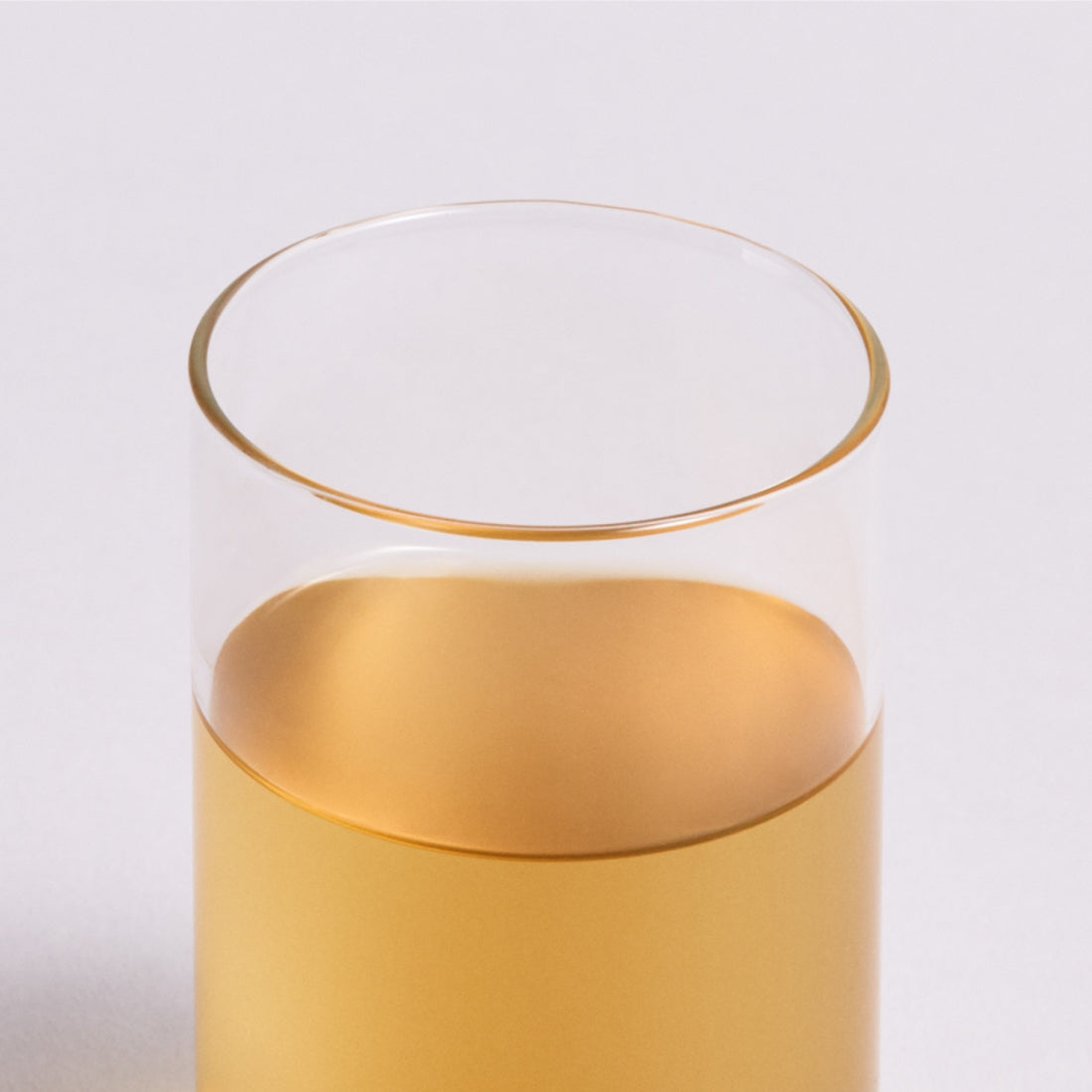 Glass of OSULLOC Peach Black Tea 20 packs with golden hue, highlighting refreshing peach flavor.