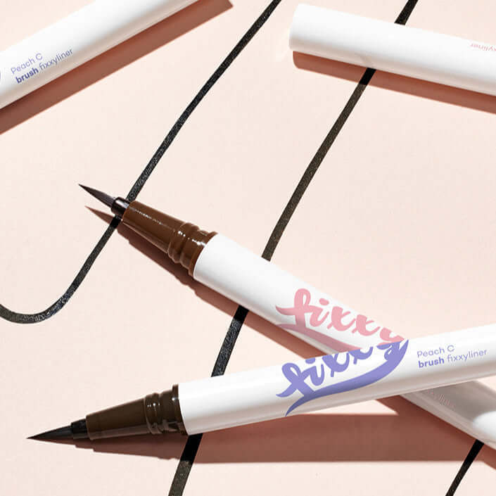 Close-up of PEACH C Brush Pixie Liner with intricate brush design on a light background.
