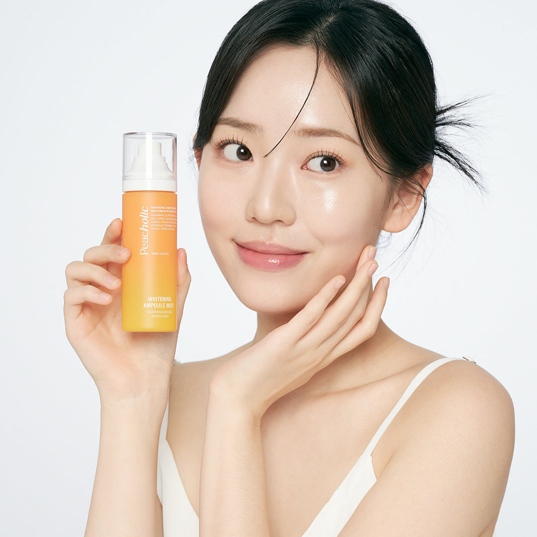 Woman holding PEACHOLIC Whitening Ampoule Mist 100ml, showcasing skincare product.