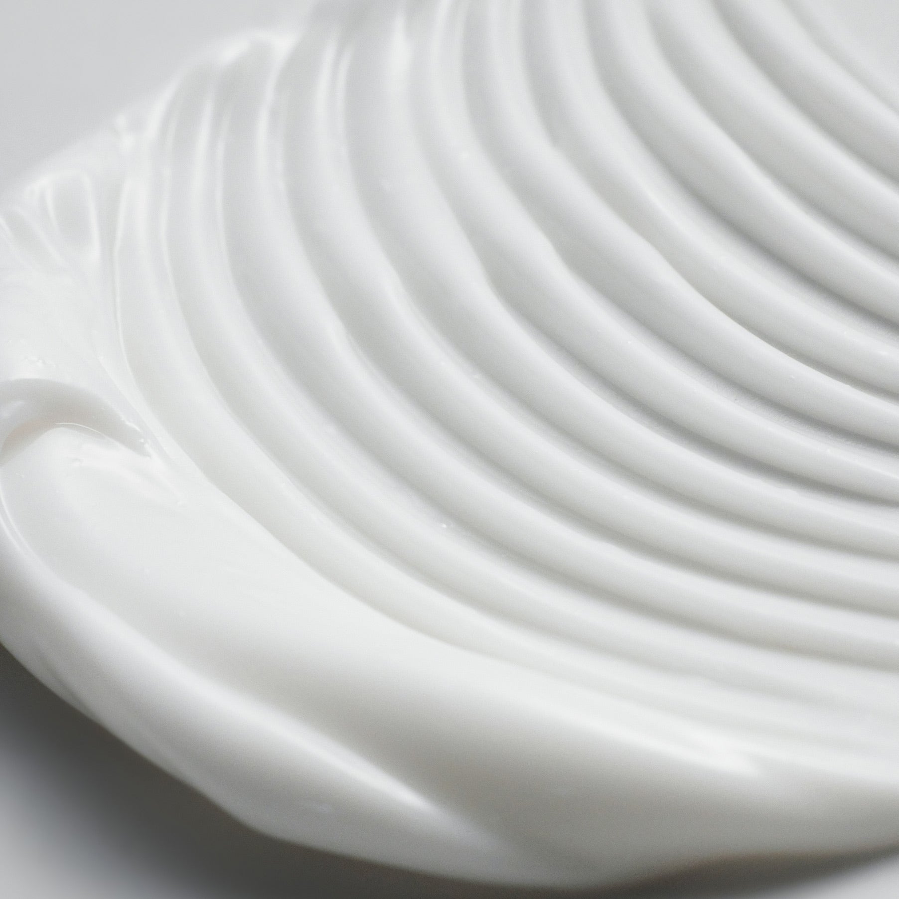 Close-up texture of PURITO Wonder Relief Centella Cream Unscented 50ml, showcasing creamy consistency on a smooth surface.