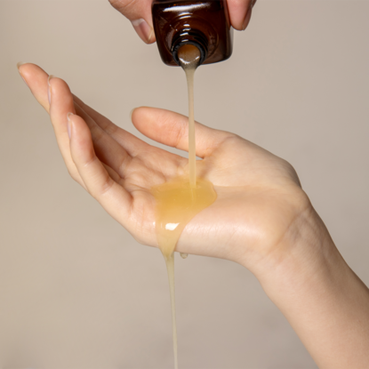 QUA-T Dia Peptide Jojoba Facial Serum 30ml being poured into hand for skincare routine