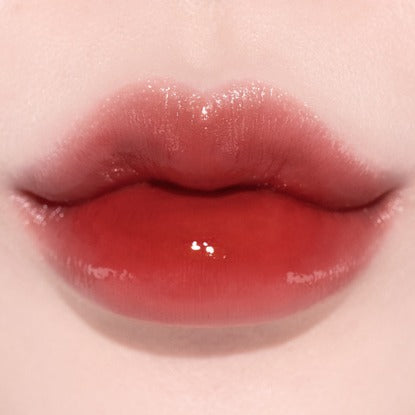 Close-up of lips wearing QUA-T The Glass Tattoo Tint, showcasing vibrant red hue and glossy finish for a smooth, tattoo-like look.