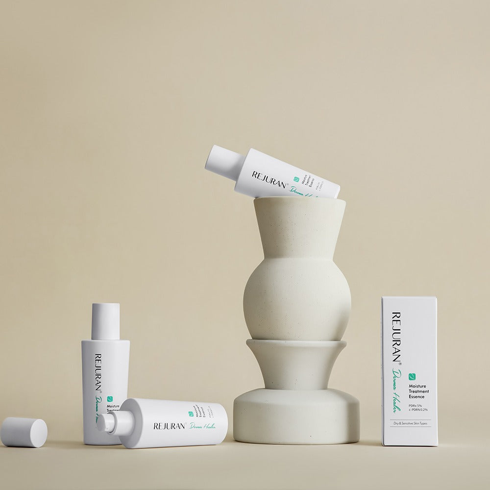 Collection of REJURAN Derma Healer Moisture Treatment Essence 70g bottles displayed artistically on a beige background.