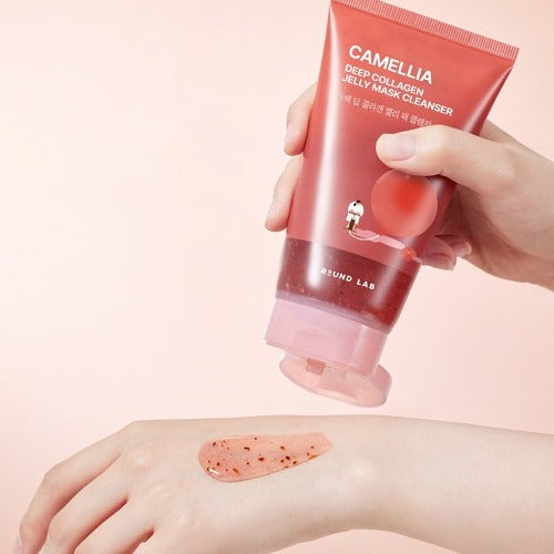 Hand holding ROUND LAB Camellia Deep Collagen Jelly Pack Cleanser 150ml with jelly pack on skin