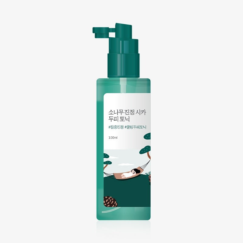 Bottle of ROUND LAB Pine Calming Cica Hair Tonic 100ml with green pump dispenser.
