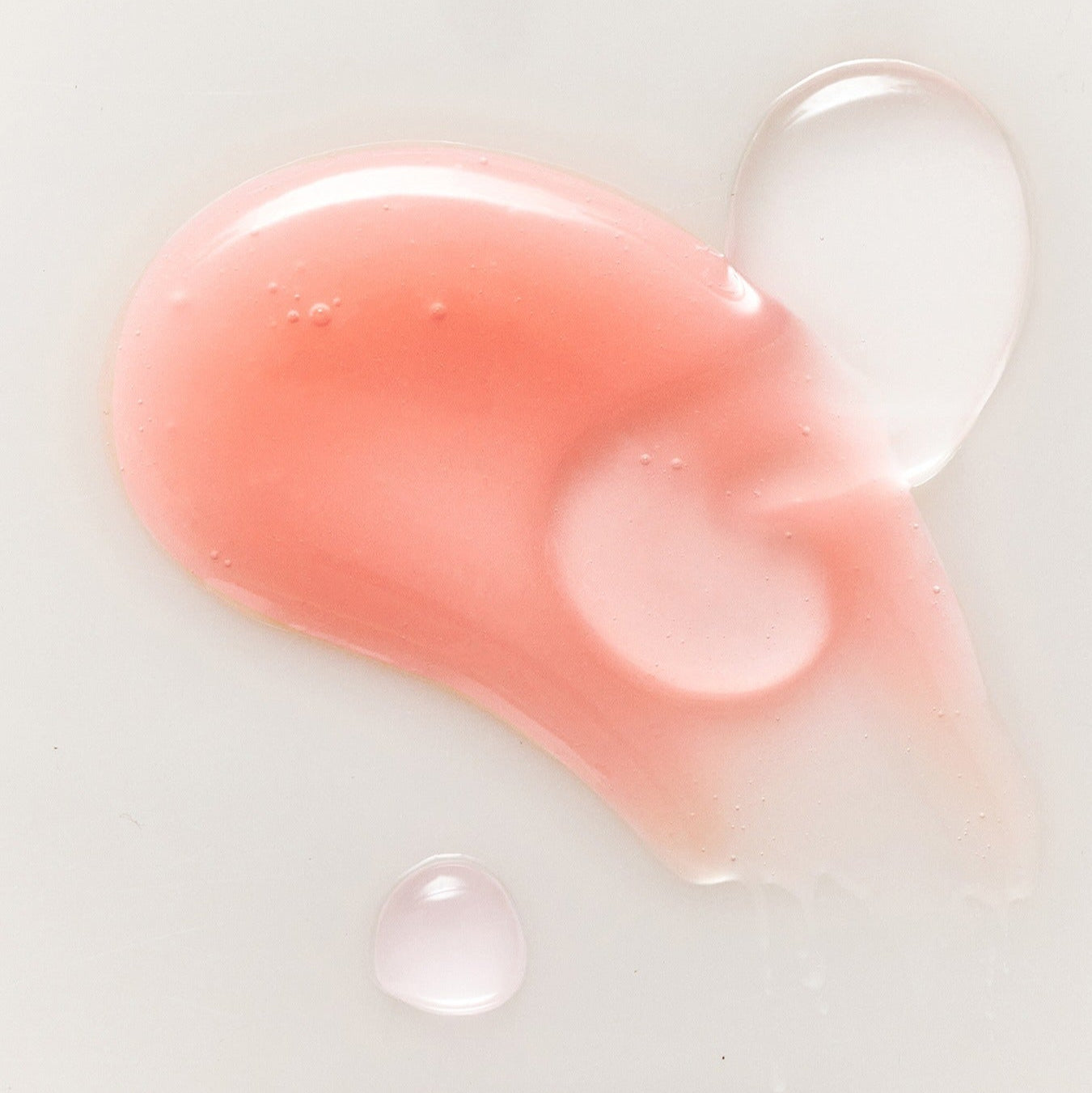 Texture of RULIDIA Shining Moment Caring Lip Balm 8g showing pink and clear gloss on a white surface.