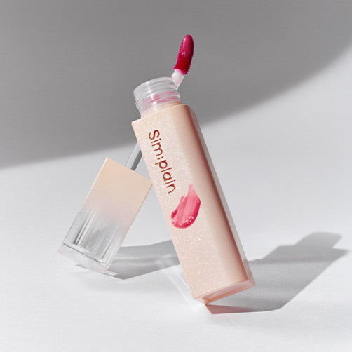 SIM;PLAIN Dewy Volume lip product with a sleek applicator and vibrant pink shade on a white background.