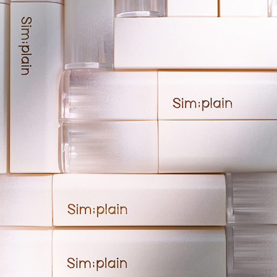 SIM;PLAIN Dewy Volume product packaging displayed in a stack, highlighting the elegant design and branding.