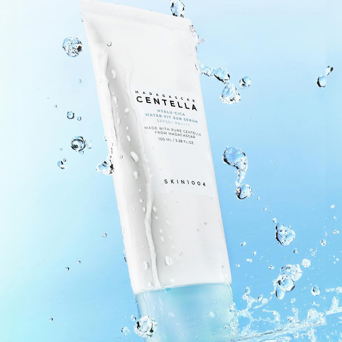 SKIN1004 Madagascar Centella Hyaluronic Acid Water-Fit Sun Serum 100ml with water droplets on blue background