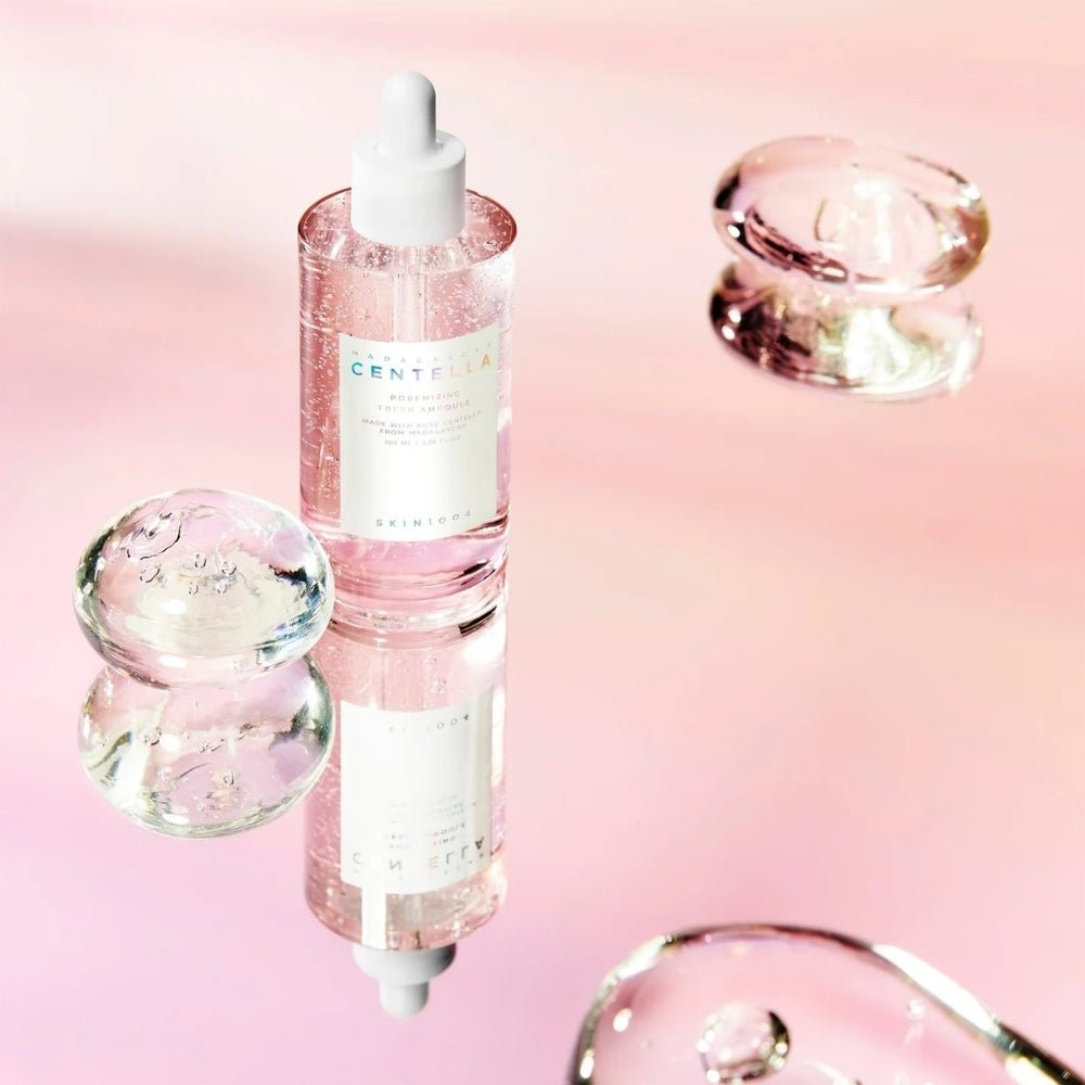 SKIN1004 Madagascar Centella Pore-Mfying Fresh Ampoule 100ml displayed with glass bubbles on a reflective pink surface