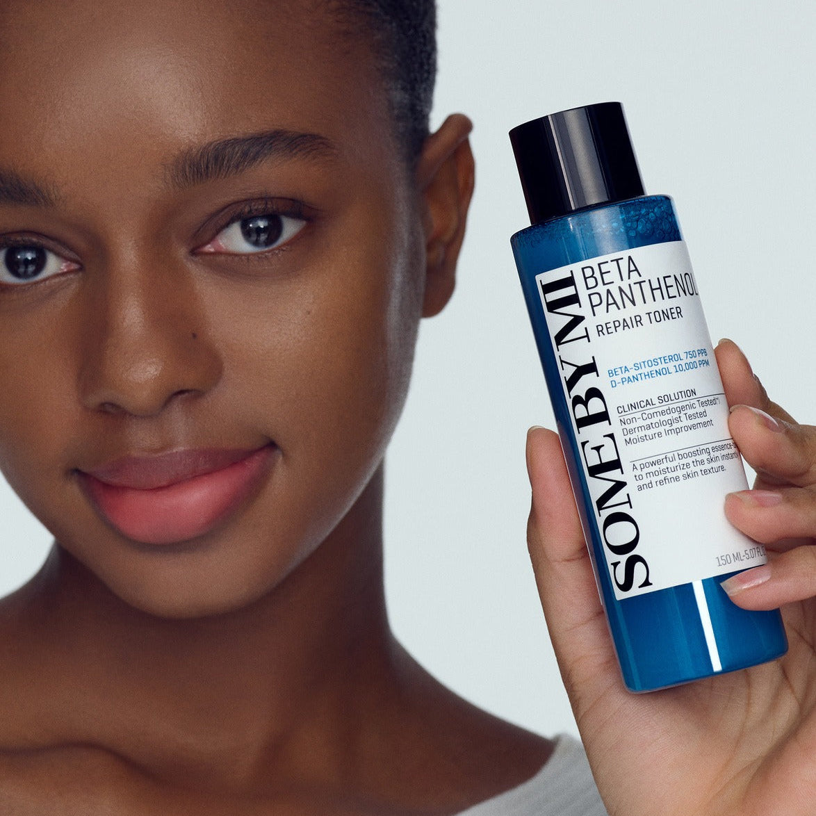 Woman holding SOME BY MI Beta Panthenol Repair Toner 150ml, showcasing skincare product.