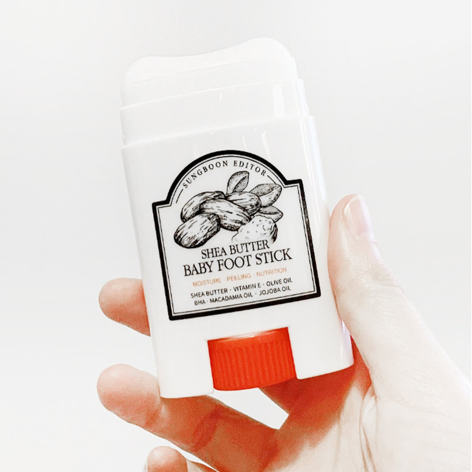 SUNGBOON EDITOR Shea Butter Baby Foot Stick held in hand for moisturizing and nourishing feet